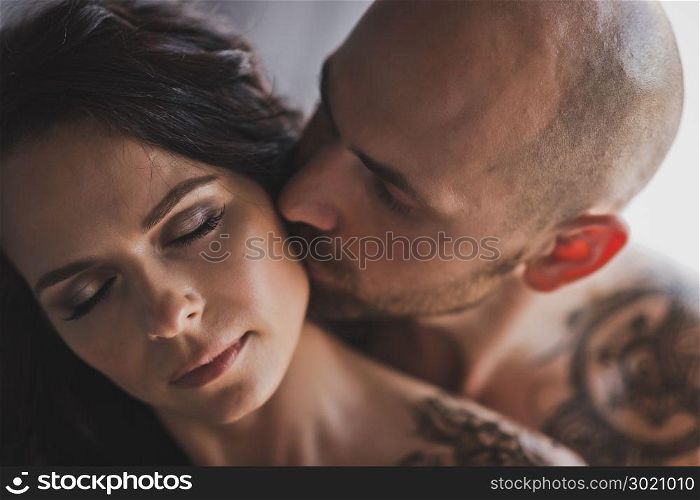 Portrait of a beautiful girl with her hair that kiss man and cheek.. Close-up portrait of cheek kissing girl men 250.