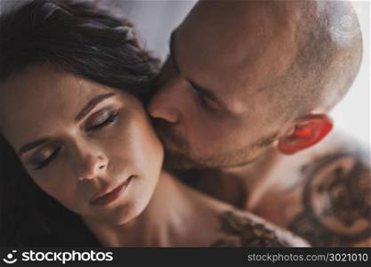 Portrait of a beautiful girl with her hair that kiss man and cheek.. Close-up portrait of cheek kissing girl men 250.