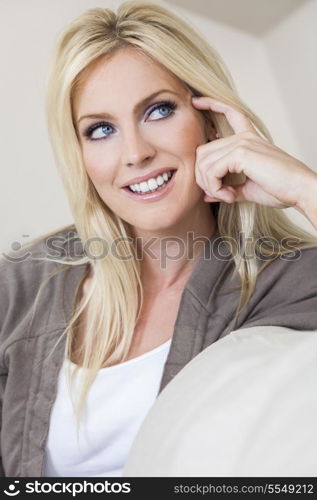 Portrait of a beautiful happy blond woman with blue eyes smiling and looking up