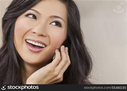 Portrait of a beautiful happy young Chinese Asian Oriental woman talking on her cell phone