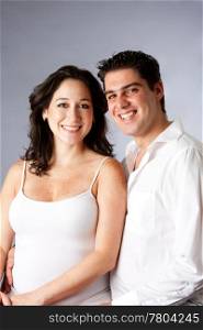 Portrait of a beautiful happy young couple smiling dressed in white, isolated
