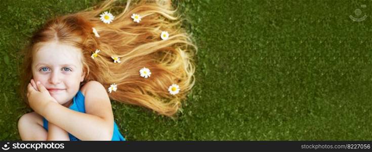 portrait of a beautiful little girl with healthy red hair with chamomile flowers lying on the grass. banner. portrait of a beautiful little girl with healthy red hair with chamomile flowers lying on the grass