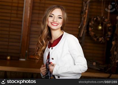 Portrait of a beautiful long-haired laughing young girl in a white jacket
