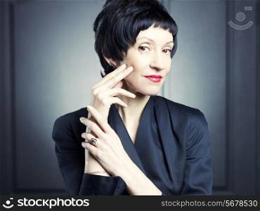 Portrait of a beautiful middle aged woman against black background