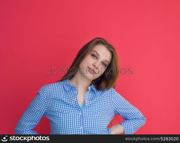 Portrait of a beautiful positive young woman while playing with her long silky hair isolated on red background