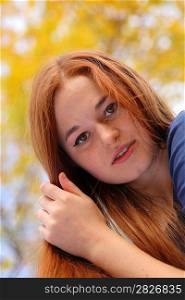 Portrait of a beautiful redhead girl smiling outdoors