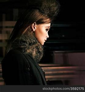 portrait of a beautiful sad girl in black with fur collar