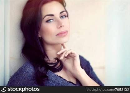 Portrait of a beautiful serious thoughtful woman outdoors in the city, gorgeous model posing over urban background, natural and authentic beauty