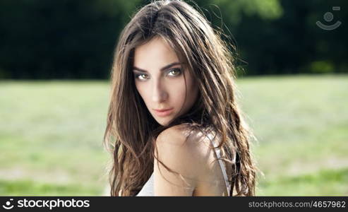 Portrait of a beautiful sexy young brunette woman in summer park