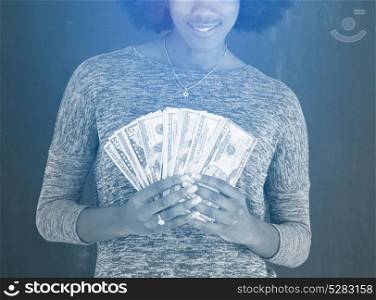 Portrait of a beautiful smiling afro american woman holding money isolated on a gray background