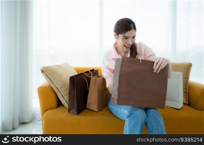 Portrait of a beautiful smiling Asian woman picking up items in a shopping bag.