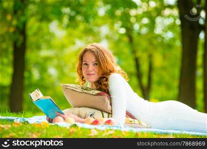 portrait of a beautiful student in a summer park with a book