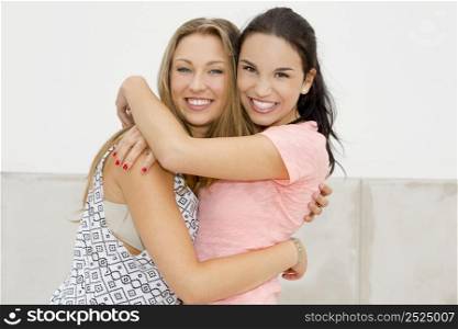 Portrait of a beautiful two young girls embracing and smiling