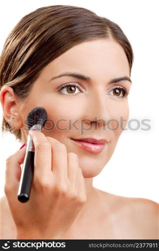 Portrait of a beautiful woman applying make-up with a brush