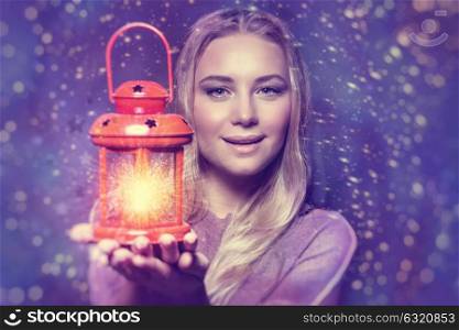 Portrait of a beautiful woman holding on hand red retro style glowing lantern over night starry sky background, magical Christmas fairytale