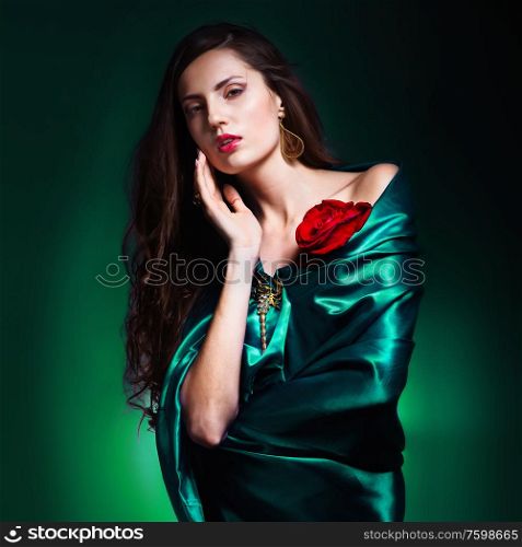 portrait of a beautiful woman in green dress whith rose