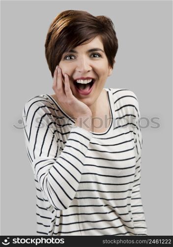 Portrait of a beautiful woman laughing, over a gray background