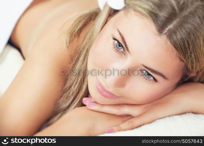 Portrait of a beautiful woman lying down on massage table at spa salon, healthy lifestyle, beauty treatment, enjoying day at the spa resort