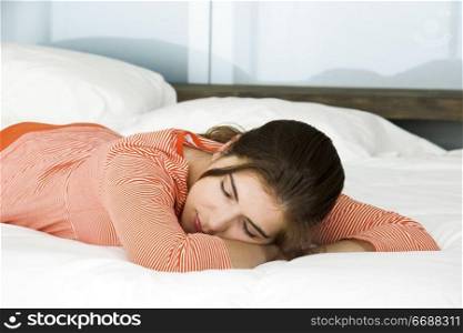 Portrait of a beautiful woman lying on a bed and sleeping