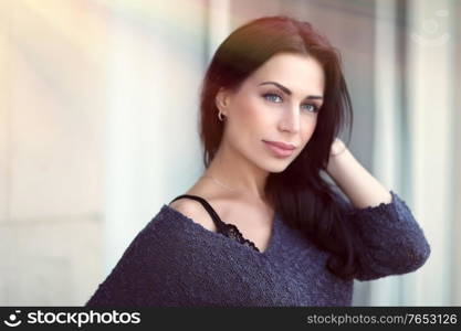 Portrait of a beautiful woman outdoors in bright sun light, attractive model posing overurban background, women&rsquo;s beauty