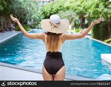 Portrait of a beautiful woman relaxing by the tropical swimming - pool