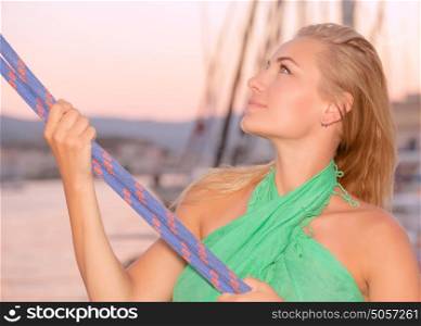 Portrait of a beautiful woman sailing, girl working on sailboat, pulling ropes, active lifestyle, enjoying traveling the world, summer vacation concept