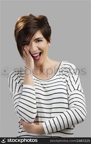 Portrait of a beautiful woman smiling, over a gray background. Woman smiling