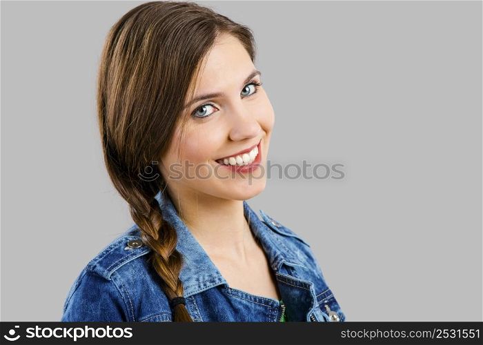 Portrait of a beautiful woman smiling over a grey background