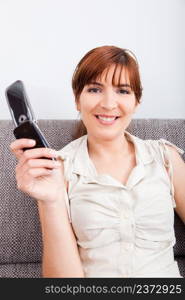 Portrait of a beautiful woman smilling and holding a cellphone