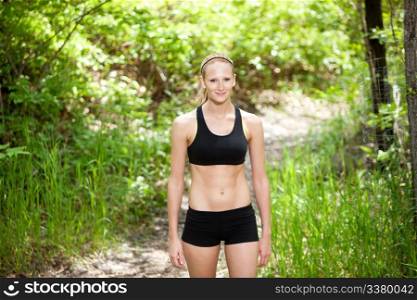 Portrait of a beautiful woman standing in sportswear against blur background