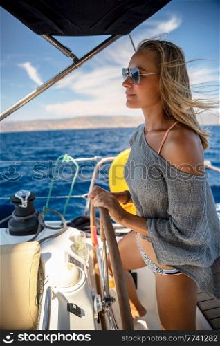 Portrait of a Beautiful Woman Steering Sailboat. Enjoying Wonderful Cruise to Greece. Happy Summer Vacation on Mediterranean Sea.. Woman Steering Sailboat