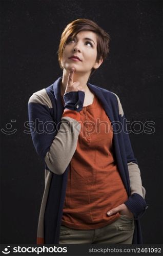 Portrait of a beautiful woman with a thinking expression, over a dark background