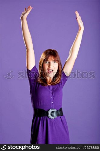 Portrait of a beautiful woman with hands on the air, over a violet background