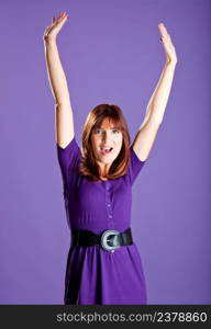 Portrait of a beautiful woman with hands on the air, over a violet background