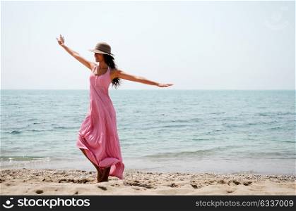 Portrait of a beautiful woman with long pink dress on a tropical beach