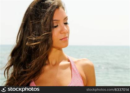 Portrait of a beautiful woman with long pink dress on a tropical beach