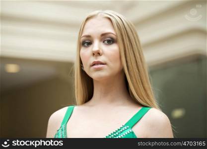 Portrait of a beautiful young blonde in green dress