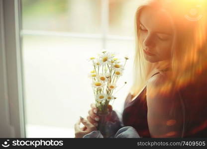 portrait of a beautiful young blonde woman with sun rays and glare