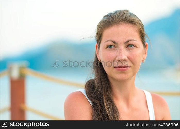 portrait of a beautiful young brunette on the pier