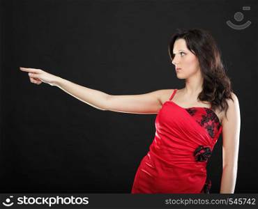 Portrait of a beautiful young business woman showing something over black background