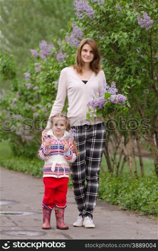 portrait of a beautiful young girl and the daughter of European type, with a bouquet of lilac in the hands of