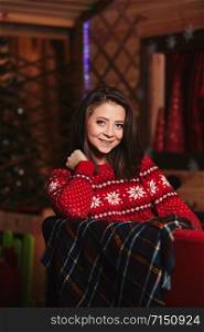 portrait of a beautiful young girl in a red Christmas sweater. Christmas background behind. holiday concept.. portrait of a beautiful young girl in a red Christmas sweater. Christmas background behind. holiday concept