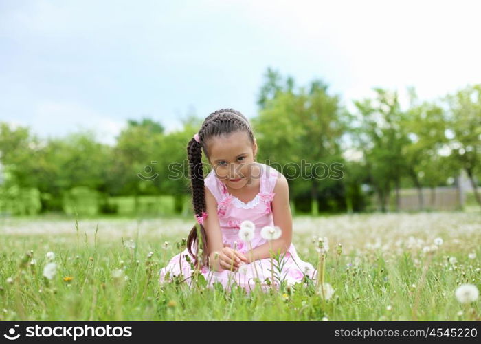 Portrait of a beautiful young girl on a green meadow.