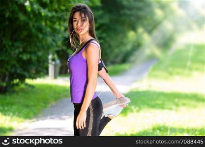 Portrait of a beautiful young girl stretching before jogging in the park on a sunny morning (copy space)