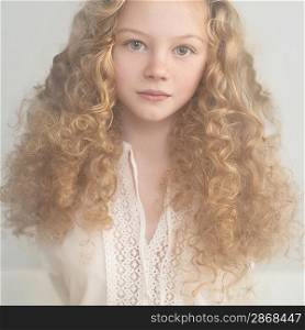 portrait of a beautiful young lady with curly blonde hair and a gentle manner