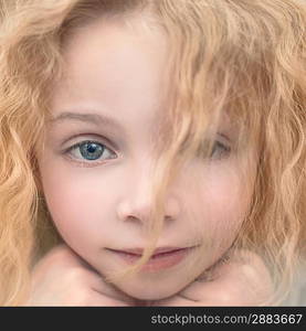 portrait of a beautiful young lady with curly blonde hair and a gentle manner