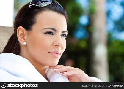 Portrait of a beautiful young Latina Hispanic woman smiling in a white bathrobe outside at a health spa