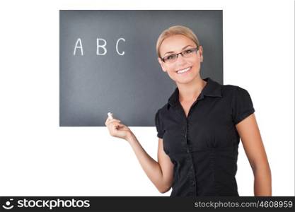 Portrait of a beautiful young teacher isolated on white background, cute female writing letters on the blackboard, teaching in an elementary school