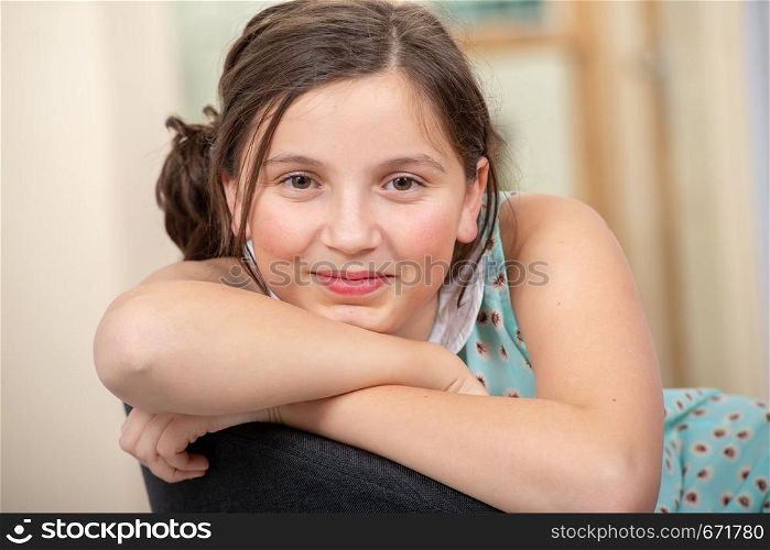 portrait of a beautiful young teenager girl sitting on armchair