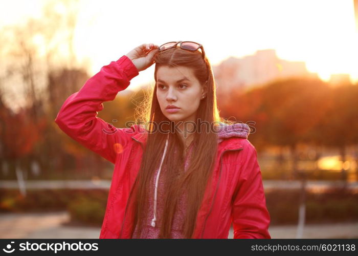 Portrait of a beautiful young traveler woman with a backpack, bright orange sunset light, traveling along Europe, freedom and active lifestyle concept